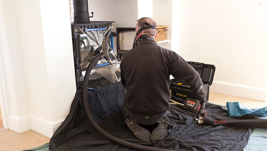 Chimney Care Co- Stock image of chimney sweep fireplace being cleaned